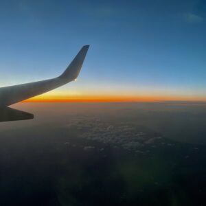 文字の入っていない、静謐な夕暮れ時の機窓からの風景。蒼い空とオレンジ色の地平線のコントラスト。