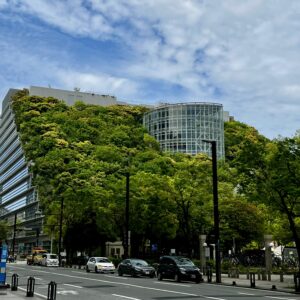 福岡・天神のシンボル、アクロス福岡。青空の下、建物を覆い尽くす鮮やかな新緑が美しく、都会のオアシスのような情景。
