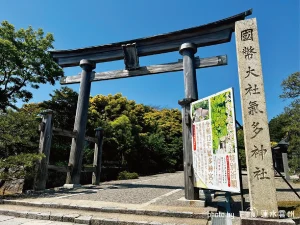 「國幣大社氣多神社」と力強く彫り込まれた古い石柱。その背後にそびえる大鳥居と、その先へと続く清浄な参道が、この聖地の入り口であることを物語っている。