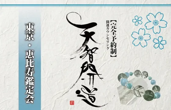 明るいオフホワイトの手漉き和紙を背景に、中央に大きく「天智開道」と力強い筆文字を配した鑑定会告知画像。左側には水色のグラデーションがかかった垂直の帯があり、その上に「東京・恵比寿鑑定会」と白い影付きの文字が凛と並んでいる。右上の余白には青い線画の桜が舞い、右下には水晶と淡い水色の天然石を組み合わせたブレスレットが置かれている。筆文字の右隣には「【完全予約制】開運カウンセリング」と黒い縦書き文字が添えられ、全体として清潔感と品格が漂う和のデザイン。