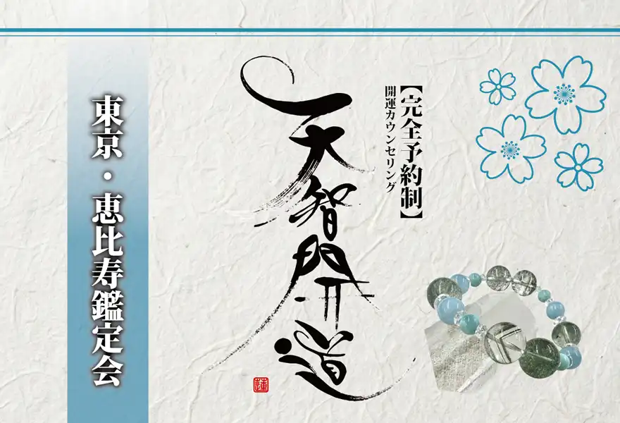 明るいオフホワイトの手漉き和紙を背景に、中央に大きく「天智開道」と力強い筆文字を配した鑑定会告知画像。左側には水色のグラデーションがかかった垂直の帯があり、その上に「東京・恵比寿鑑定会」と白い影付きの文字が凛と並んでいる。右上の余白には青い線画の桜が舞い、右下には水晶と淡い水色の天然石を組み合わせたブレスレットが置かれている。筆文字の右隣には「【完全予約制】開運カウンセリング」と黒い縦書き文字が添えられ、全体として清潔感と品格が漂う和のデザイン。