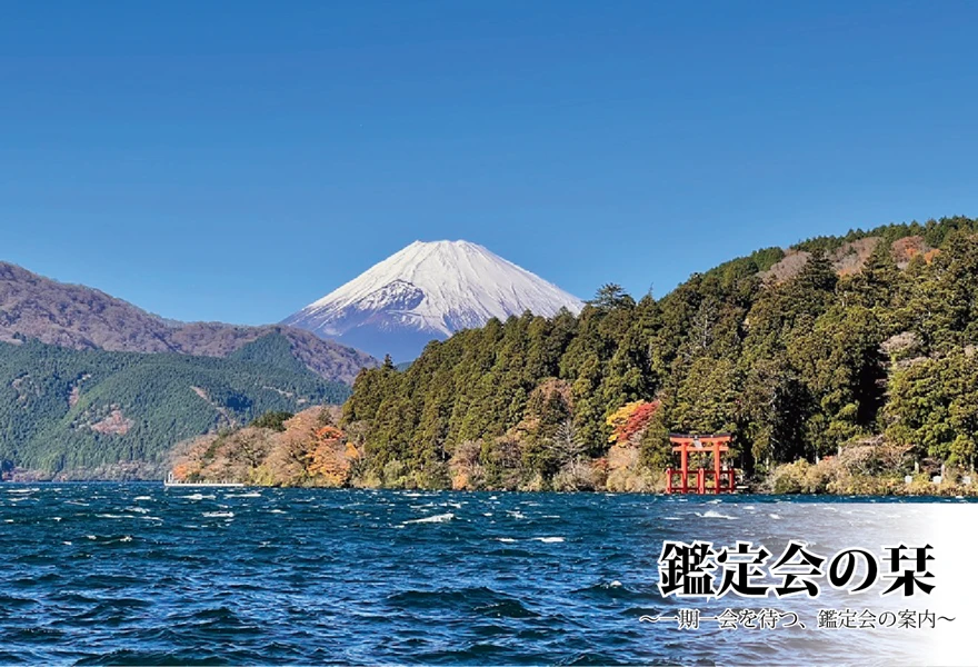 青く波立つ芦ノ湖の向こうに、雪化粧をした美しい富士山がそびえ立つ風景。豊かな緑の木々が茂る岸辺には、湖面に佇む箱根神社の大きな赤い平和の鳥居が見えています。右下には「鑑定会の栞 〜一期一会を待つ、鑑定会の案内〜」という文字が配置されています。