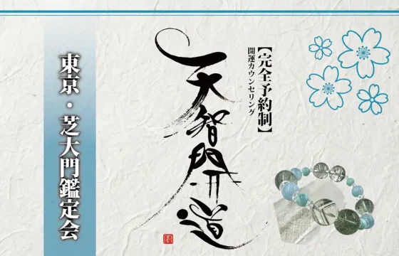 明るいオフホワイトの手漉き和紙を背景に、中央に大きく「天智開道」と力強い筆文字を配した鑑定会告知画像。左側には水色のグラデーションがかかった垂直の帯があり、その上に「東京・芝大門鑑定会」と白い影付きの文字が凛と並んでいる。右上の余白には青い線画の桜が舞い、右下には水晶と淡い水色の天然石を組み合わせたブレスレットが置かれている。筆文字の右隣には「【完全予約制】開運カウンセリング」と黒い縦書き文字が添えられ、全体として清潔感と品格が漂う和のデザイン。