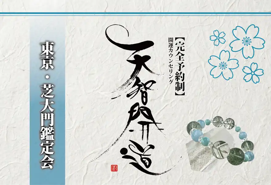 明るいオフホワイトの手漉き和紙を背景に、中央に大きく「天智開道」と力強い筆文字を配した鑑定会告知画像。左側には水色のグラデーションがかかった垂直の帯があり、その上に「東京・芝大門鑑定会」と白い影付きの文字が凛と並んでいる。右上の余白には青い線画の桜が舞い、右下には水晶と淡い水色の天然石を組み合わせたブレスレットが置かれている。筆文字の右隣には「【完全予約制】開運カウンセリング」と黒い縦書き文字が添えられ、全体として清潔感と品格が漂う和のデザイン。