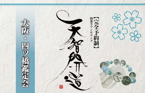 明るいオフホワイトの手漉き和紙を背景に、中央に大きく「天智開道」と力強い筆文字を配した鑑定会告知画像。左側には水色のグラデーションがかかった垂直の帯があり、その上に「大阪・四ツ橋鑑定会」と白い影付きの文字が凛と並んでいる。右上の余白には青い線画の桜が舞い、右下には水晶と淡い水色の天然石を組み合わせたブレスレットが置かれている。筆文字の右隣には「【完全予約制】開運カウンセリング」と黒い縦書き文字が添えられ、全体として清潔感と品格が漂う和のデザイン。