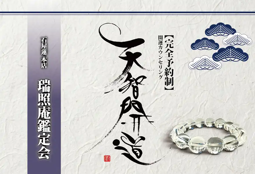 明るいオフホワイトの手漉き和紙を背景に、中央に大きく「天智開道」と力強い筆文字を配した「瑞照庵鑑定会」の告知画像。左側には深みのある藍紫のグラデーション帯があり、その上に「石屋蓮 本店 瑞照庵鑑定会」と白い影付きの文字が凛と並んでいる。右上の余白には藍色と白の線画で描かれた松の紋様が舞い、右下には水晶の透明感が際立つ天然石ブレスレットが置かれている。全体として静謐さと重厚な品格を併せ持つ、特別な空間を感じさせるデザイン。