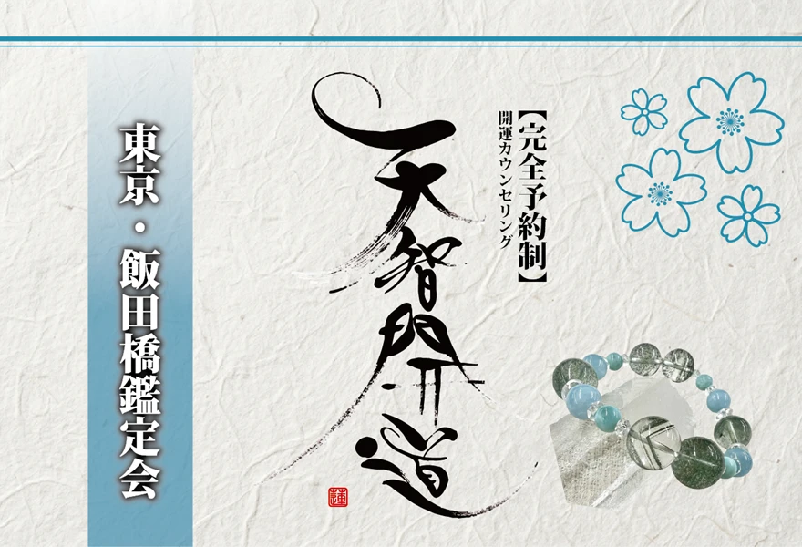 明るいオフホワイトの手漉き和紙を背景に、中央に大きく「天智開道」と力強い筆文字を配した鑑定会告知画像。左側には水色のグラデーションがかかった垂直の帯があり、その上に「東京・飯田橋鑑定会」と白い影付きの文字が凛と並んでいる。右上の余白には青い線画の桜が舞い、右下には水晶と淡い水色の天然石を組み合わせたブレスレットが置かれている。筆文字の右隣には「【完全予約制】開運カウンセリング」と黒い縦書き文字が添えられ、全体として清潔感と品格が漂う和のデザイン。