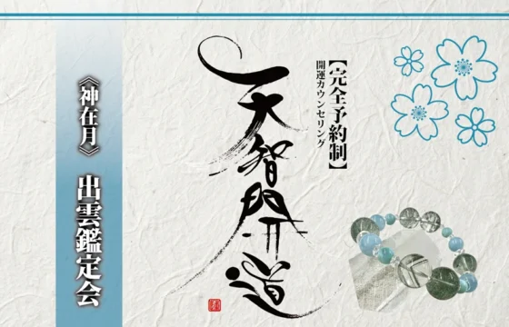 明るいオフホワイトの手漉き和紙を背景に、中央に大きく「天智開道」と力強い筆文字を配した鑑定会告知画像。左側には水色のグラデーションがかかった垂直の帯があり、その上に「《神在月》出雲鑑定会」と白い影付きの文字が凛と並んでいる。右上の余白には青い線画の桜が舞い、右下には水晶と淡い水色の天然石を組み合わせたブレスレットが置かれている。筆文字の右隣には「【完全予約制】開運カウンセリング」と黒い縦書き文字が添えられ、全体として清潔感と品格が漂う和のデザイン。