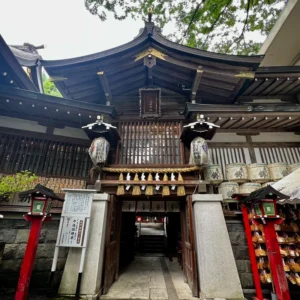 境内に鎮座する金刀比羅神社の歴史を感じさせる木造の拝殿。軒下には大きな注連縄が張られ、その左右には奉納された日本酒の樽が何段にも積み上げられている。古びた石灯籠や、参拝客の願いが込められた無数の絵馬が並び、この土地に根付いた信仰の厚さを物語っている。