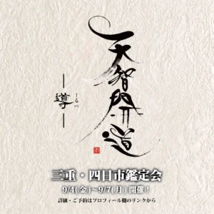 風合いのある生成りの和紙を背景に、力強く迷いのない筆致で「天智開道」と大きく墨文字が書かれている。その左側には「導」の文字が添えられ、さらに鑑定会の詳細(三重・四日市鑑定会、9/4(金)-9/7(月))が明朝体で記されている。文字の周囲には、和紙特有の繊維の質感が感じられ、中央には店主の「蓮水雲州」の印と思われる小さな赤い落款が押されている。鑑定会に対する真摯な姿勢と、人々の進むべき道を照らす強い意志が込められた書となっている。