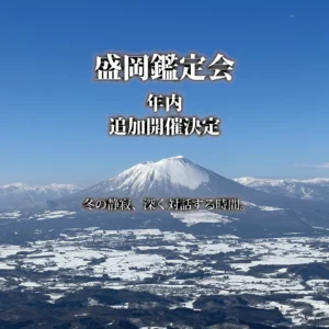 冬の澄んだ青空の下に広がる雪化粧した岩手山と、眼下の雪景色を捉えた空撮写真。画面上部には白く縁取られた大きな文字で「盛岡鑑定会 年内追加開催決定」、下部には「冬の静寂、深く対話する時間。」と重ねられている。